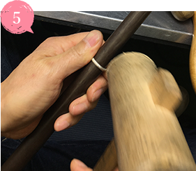 鉄のサイズ棒に通して小さなハンマーで指輪のサイズを10号に調整していきます。